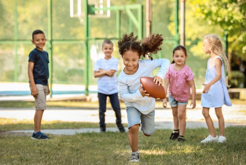Girl running with football Flurl 3 ways to help your kids stay healthy during the summer months